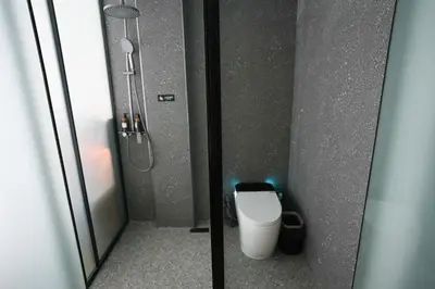 a bathroom with a shower and a toilet in a stall at Haiman Hotel\u6d77\u66fc\u9152\u5e97 in Bangkok