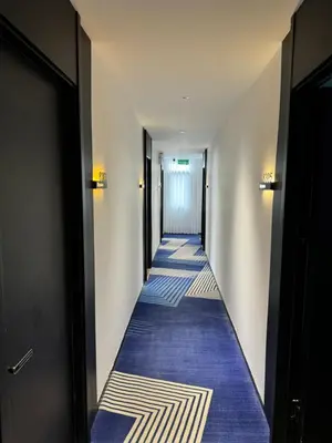 a hallway with blue carpeting in a building at Haiman Hotel\u6d77\u66fc\u9152\u5e97 in Bangkok