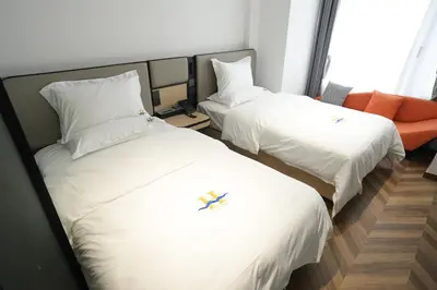 two beds in a hotel room with white sheets at Haiman Hotel\u6d77\u66fc\u9152\u5e97 in Bangkok