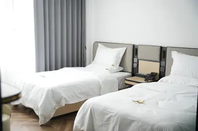 two beds in a hotel room with white sheets at Haiman Hotel\u6d77\u66fc\u9152\u5e97 in Bangkok