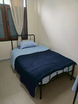 a bedroom with a bed with a blue comforter and a window at 212 Cozy room with private balcony in Bangkok