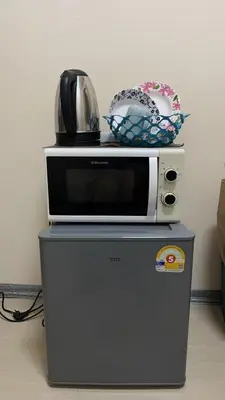 a microwave sitting on top of a refrigerator at 212 Cozy room with private balcony in Bangkok