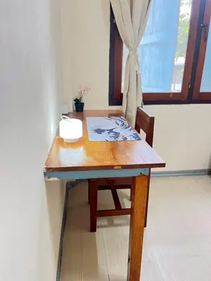a wooden table with a chair and a window at 212 Cozy room with private balcony in Bangkok