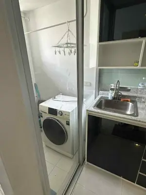 a small kitchen with a sink and a washing machine at The Room Sukhumvit 64 Punnawithi in Phra Khanong