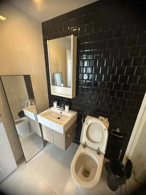 a bathroom with a white toilet and a sink at The Room Sukhumvit 64 Punnawithi in Phra Khanong