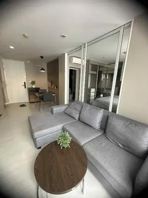 a living room with a couch and a table at The Room Sukhumvit 64 Punnawithi in Phra Khanong