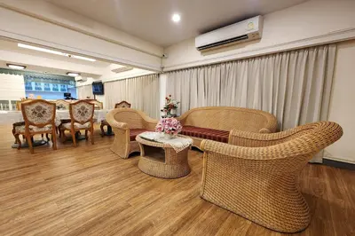 a living room with wicker chairs and a table and a tablektop at Suan Sunandha Palace Hotel in Bangkok