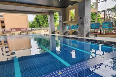 a large swimming pool with blue tiles in a building at Suan Sunandha Palace Hotel in Bangkok