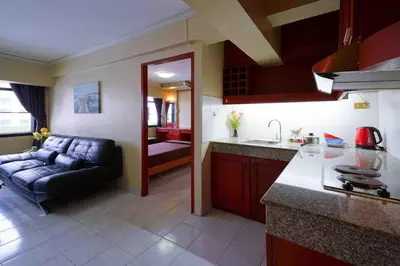 a kitchen and a living room with a couch at Petch Tower Ekamai Budget Serviced Apartments in Bangkok