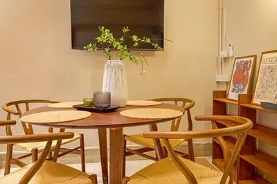a dining room with a table and chairs with a vase at Newly Renovated, 4BR Townhouse , 5min MRT , Group in Bangkok