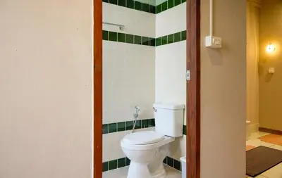 a bathroom with a toilet and green and white tiles at Newly Renovated, 4BR Townhouse , 5min MRT , Group in Bangkok