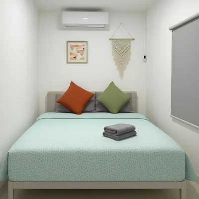 a small bedroom with a bed with colorful pillows at 3BR max 9pax near MRT Ratchada Good for group in Bangkok