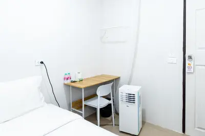 a small desk with a chair next to a bed at XX The Hidden khaosen เดอะ ฮิดเด้น ตรอกข้าวสาร in Bangkok