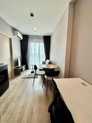 a living room with a table and chairs in a room at Luxury 1 BR Bangkok New CBD High Fl MRT Rama 9 in Bangkok
