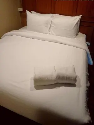 a white bed with white pillows and a towel on it at XX Stay On Sukhumvit 11 - สเตย์ออน สุขุมวิท ซอย 11 in Bangkok