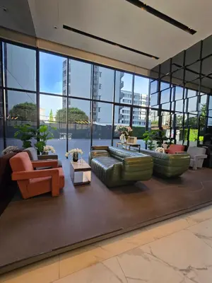 a lobby with couches and tables and windows at Fully equipped Ideo Rama9-Asoke, with workstation in Bangkok