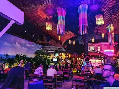 people sitting at tables in a restaurant with lights at XX GO INN Khaosan Road BKK - โก อินน์ ถนนข้าวสาร กรุงเทพ in Bangkok