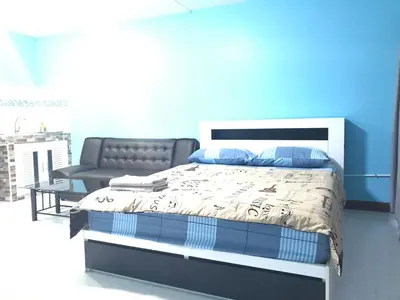 a bedroom with a bed and a blue wall at Muangthongthani Rental/Khun Dan in Nonthaburi