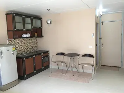 a kitchen with a table and chairs and a refrigerator at Muangthongthani Rental/Khun Dan in Nonthaburi