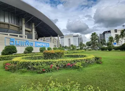 a park in front of a building with flowers and plants at Popular Muang Thong Condo,Building 5 in Thung Si Kan