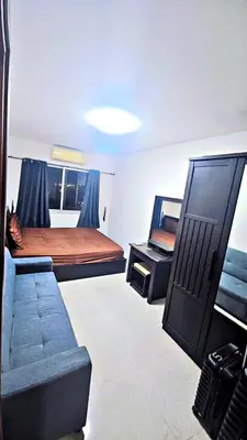a room with two beds and a couch in it at River View 9 in Bangkok