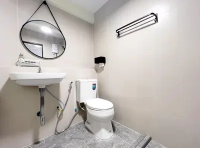 a bathroom with a toilet and a sink and a mirror at Baan Ploen Dee - Wat Arun in Bangkok