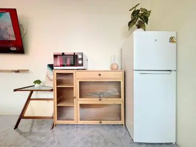 a kitchen with a white refrigerator and a table at Baan Ploen Dee - Wat Arun in Bangkok