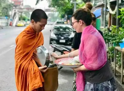 a man and a woman holding a plate of food at Baan Ploen Dee - Wat Arun in Bangkok