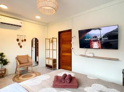 a bedroom with a tv on the wall and a chair at Baan Ploen Dee - Wat Arun in Bangkok