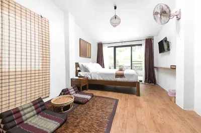 a living room with a bed and a couch at Baan Ploen Dee - Wat Arun in Bangkok