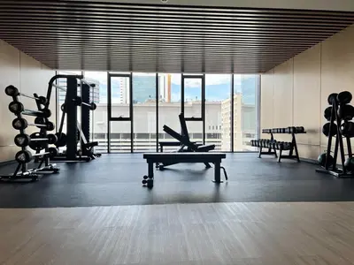 a gym with a large window and exercising machines at The Prestige Suites Rama 9 in Bangkok