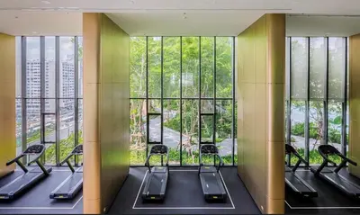 a gym with a row of chairs and large windows at The Prestige Suites Rama 9 in Bangkok