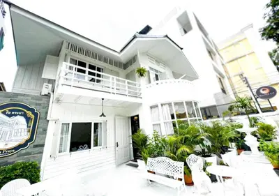 a white house with white tables and chairs at RQ Timeless Dinsor Cultural Heritage House in Bangkok