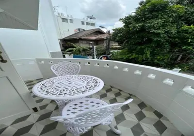 a white table and two chairs on a balcony at RQ Timeless Dinsor Cultural Heritage House in Bangkok