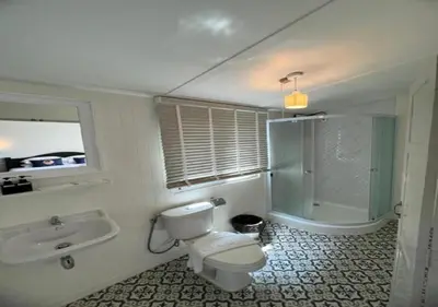 a bathroom with a toilet and a sink and a shower at RQ Timeless Dinsor Cultural Heritage House in Bangkok