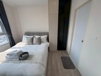 a bedroom with a white bed with a black headboard at High Floor Luxury Studio with Great Views in Sathani Ban Hua Mak