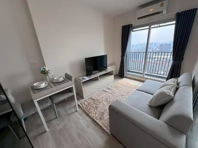 a living room with a couch and a large window at High Floor Luxury Studio with Great Views in Sathani Ban Hua Mak