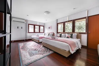 a bedroom with two beds and a rug at MIQ S22 Pool Villa PhromPhong Emsphere 5BR in Bangkok