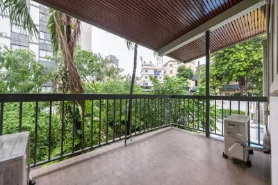a balcony with a view of a palm tree at MIQ S22 Pool Villa PhromPhong Emsphere 5BR in Bangkok