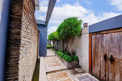an alley with a brick wall and a wooden gate at Luxury Pure Modern Pool Villa 5Bed KTV Gym Nr BTS&Central in Bangkok