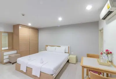 a bedroom with a large white bed and a desk at Townhouse Siam Privi Hotel in Bangkok