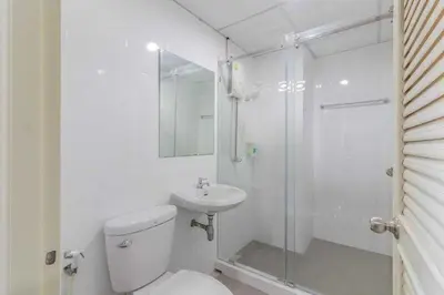 a bathroom with a toilet and a shower and a sink at Townhouse Siam Privi Hotel in Bangkok