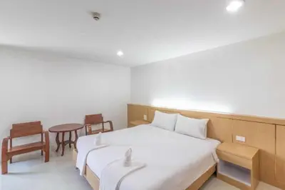 a bedroom with a bed and a table and chairs at Townhouse Siam Privi Hotel in Bangkok