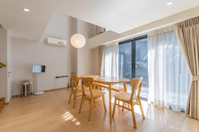 a dining room with a table and chairs and a large window at Heaven Thonglor 36 - Villa in Bangkok