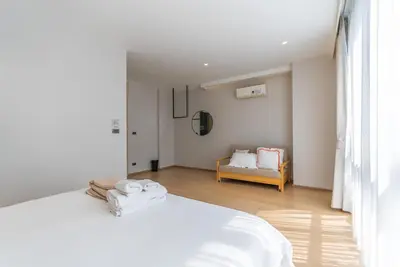 a white bedroom with a bed and a couch at Heaven Thonglor 36 - Villa in Bangkok