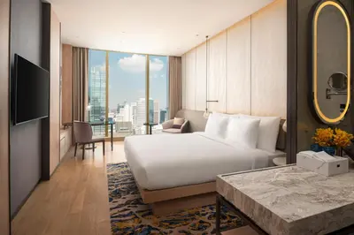 a hotel room with a bed and a large window at Grand Nikko Bangkok Sathorn in Bangkok