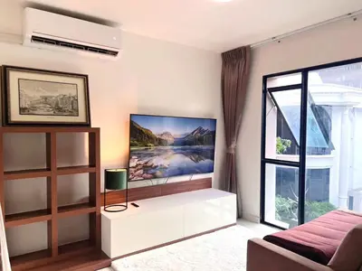a living room with a large tv on the wall at Best City Location with 3-min Walk to Everything in Bangkok