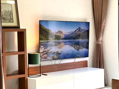 a tv sitting on a stand in a room at Best City Location with 3-min Walk to Everything in Bangkok