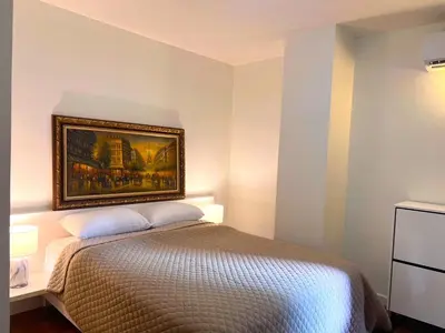 a bedroom with a bed with a painting on the wall at Best City Location with 3-min Walk to Everything in Bangkok