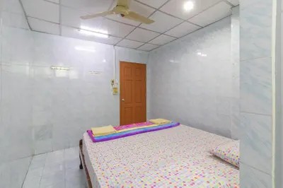 a small room with a bed and a ceiling at New Central Guesthouse in Bangkok